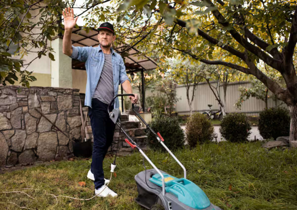A male landscaper mowing the lawn