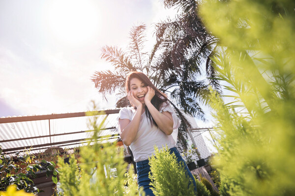 Smiling woman enjoying lush garden landscape design