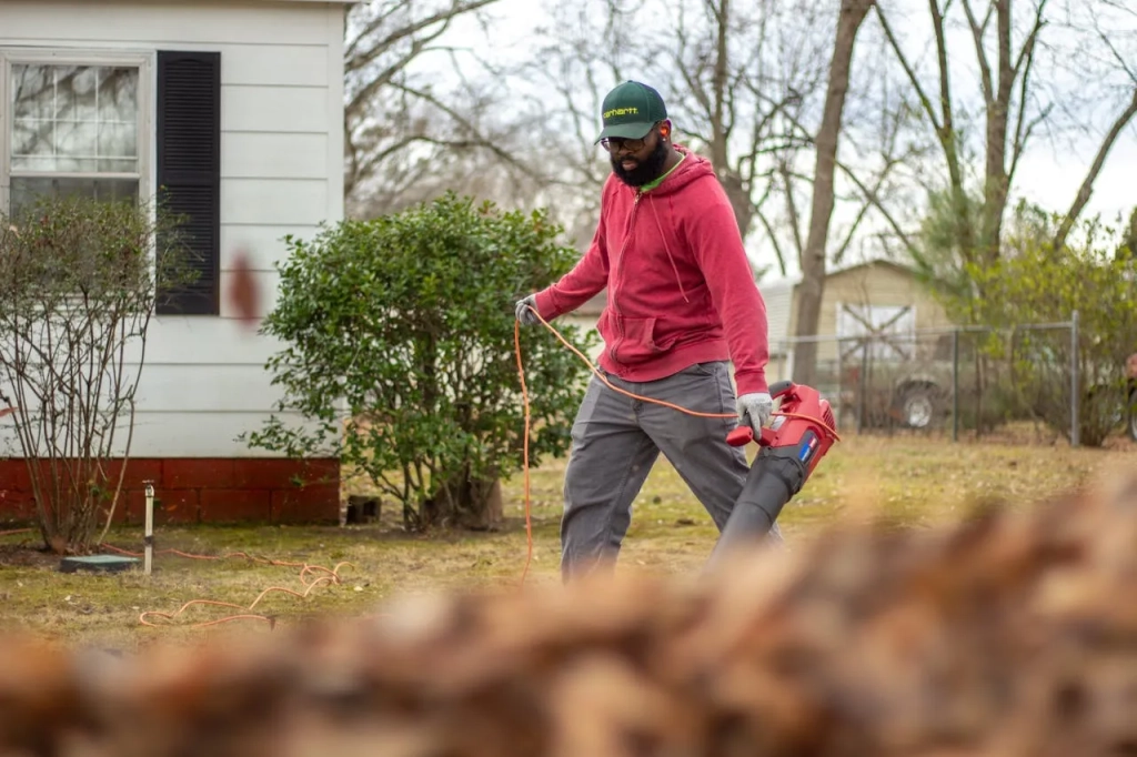 A man holding a leaf blower
